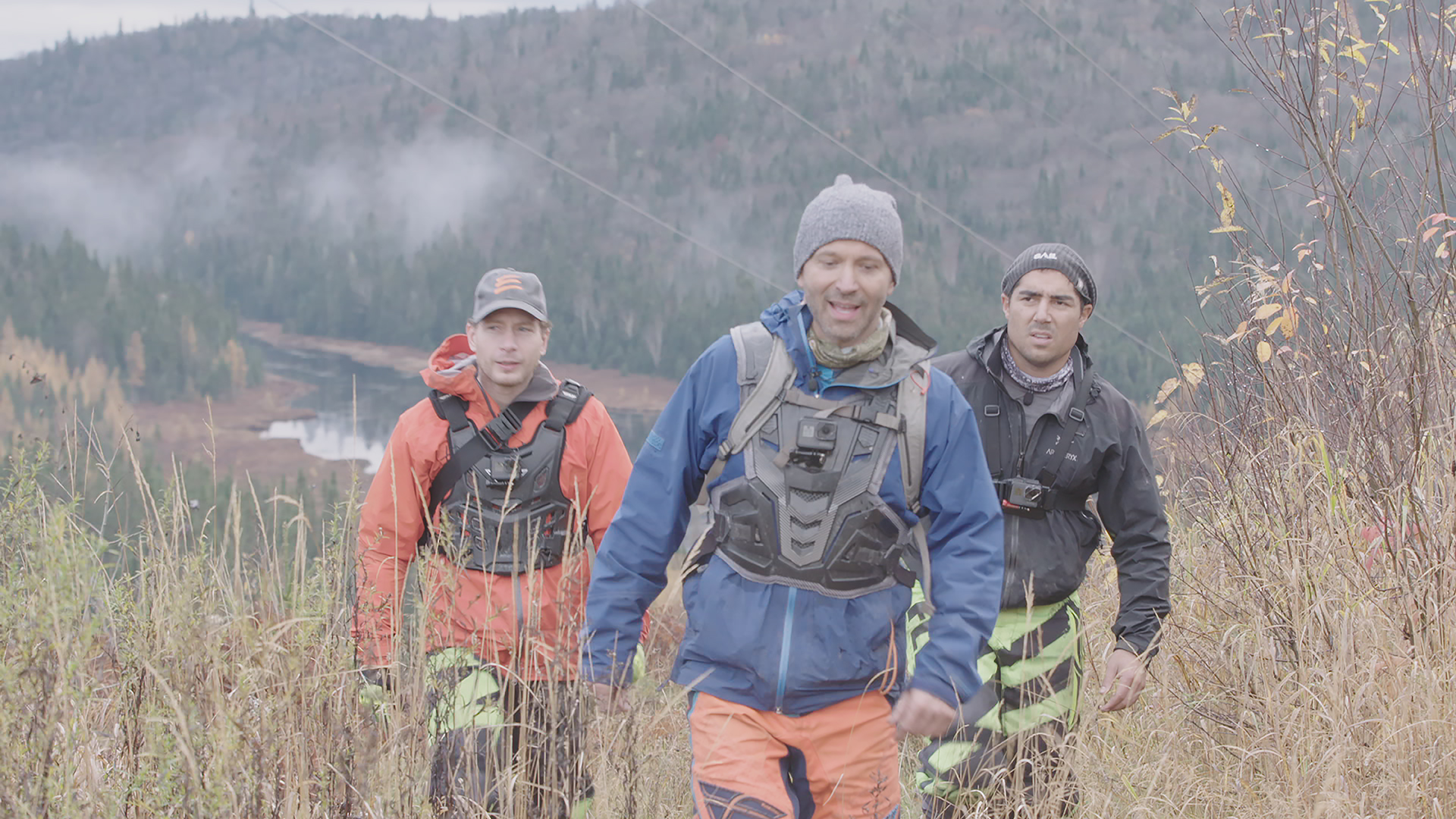 joel legendre, francis bouillon et le guide de survie en forêt en marche dans un champ dans expedition extreme