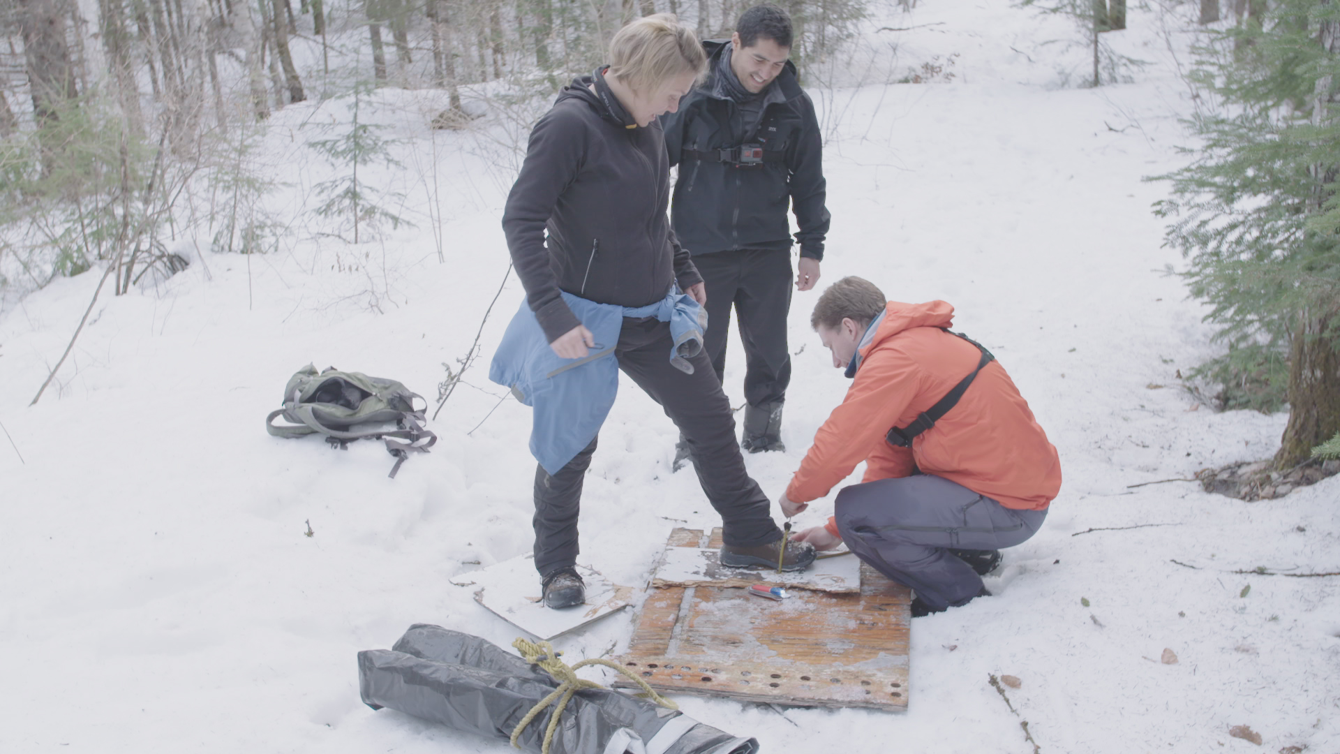 veronique claveau se faisant installer des raquettes temporaires par le guide de survie en forêt assisté de francis bouillon expedition extreme